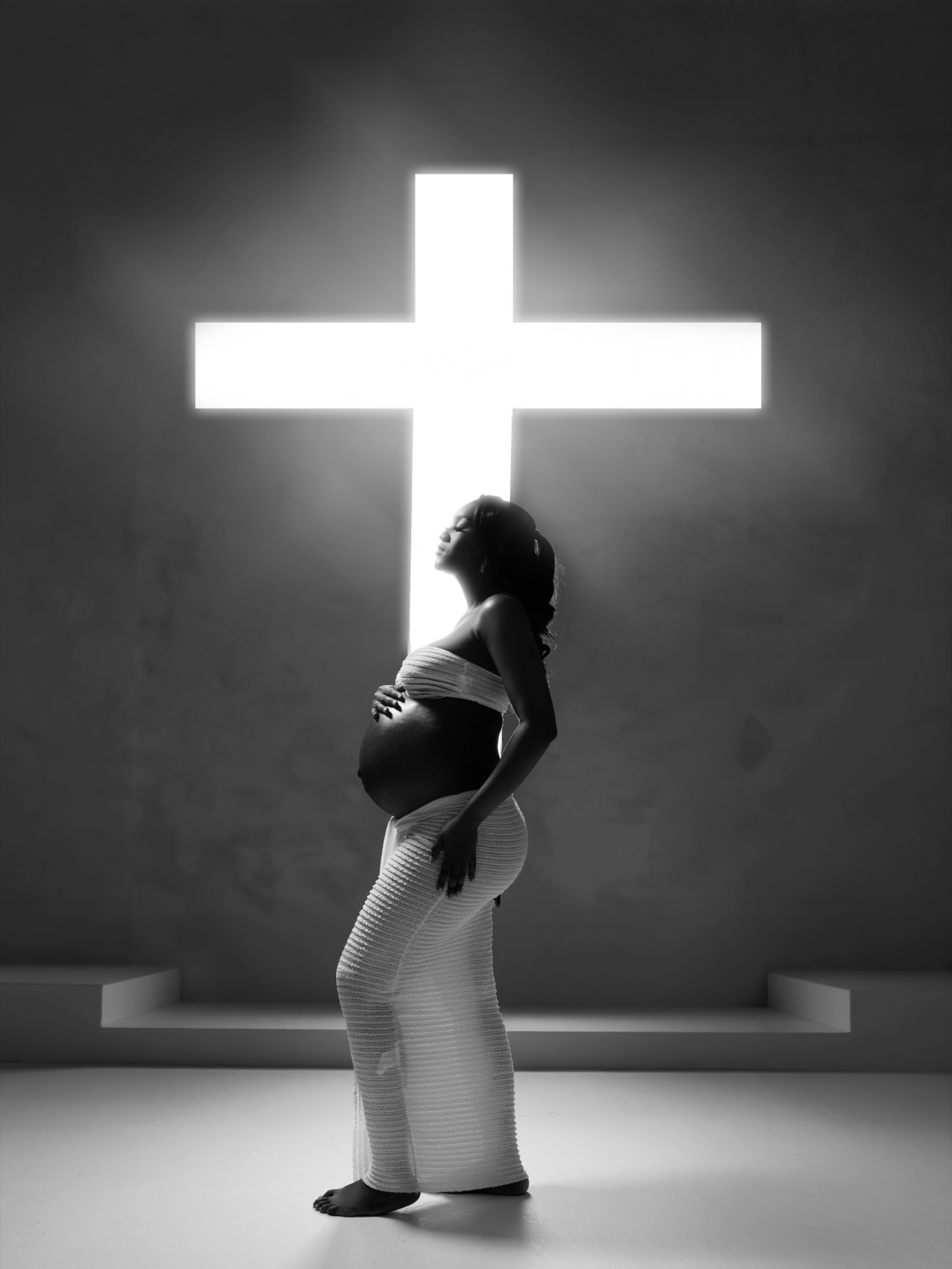Maternity portrait in flowing fabric on a warm backdrop